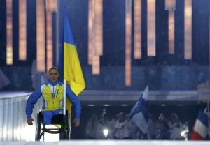 Украина's flag-bearer Tkachenko проходит в стадии в период завершения празднования 2014 года Paralympic Winter Games in Sochi