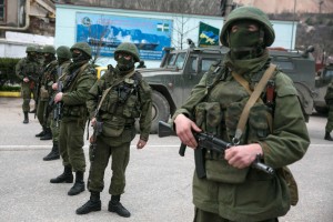 Обслуженный служащий stand near Russian army vehicles outside Russian border guard post in the Crimean town of Balaclava