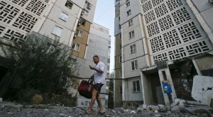 A man walks on rubble near an apartment block damaged by what locals say was shelling by Ukrainian forces in Donetsk