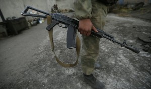 Russian serviceman holds his Kalashnikov assault rifle at checkpoint on road near the eastern Russian city of Horlivka